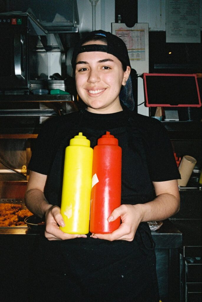 Staff member holding condiments in restaurant