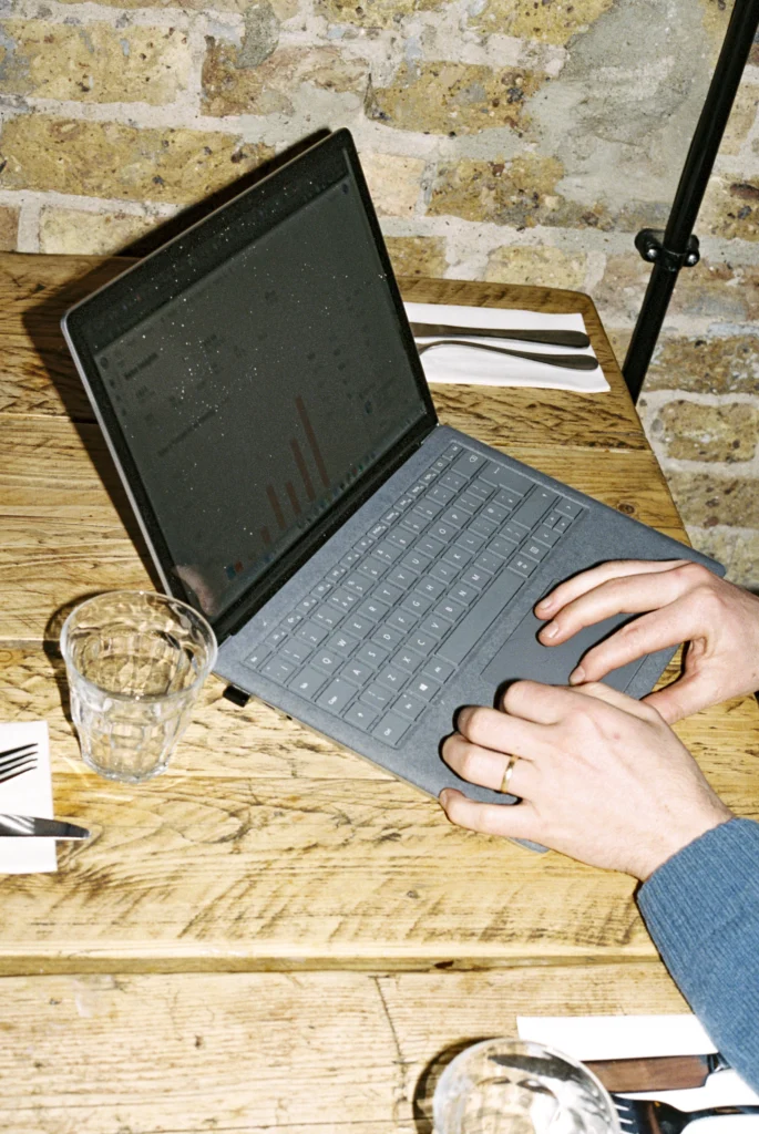 Person using a laptop to review restaurant data analytics