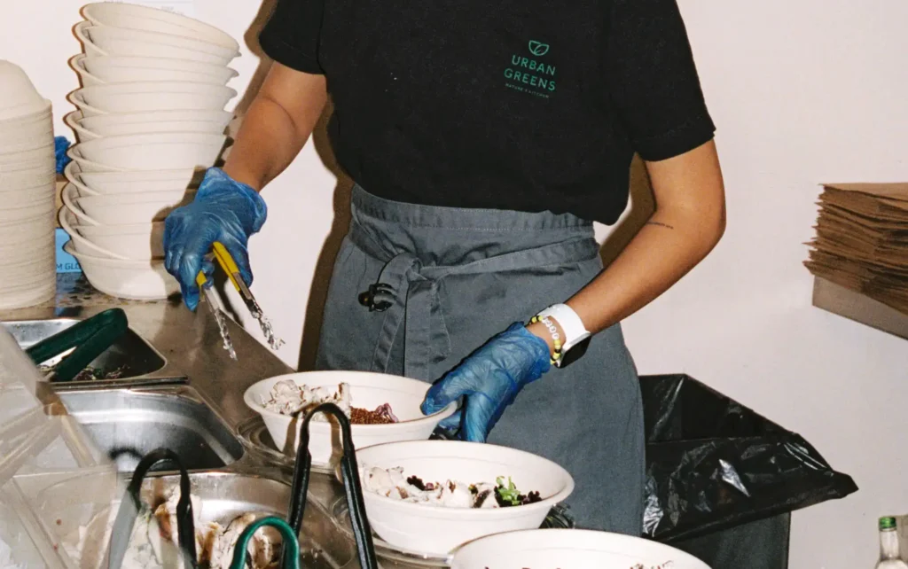 Employee serving food in salad bowls