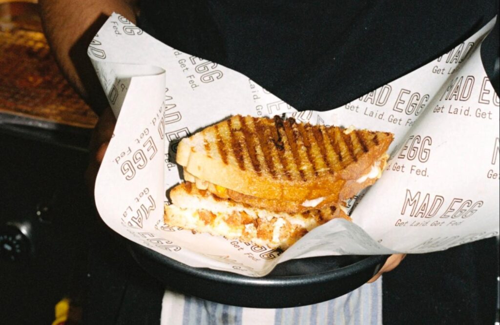 A chef holding a freshly toasted sandwich