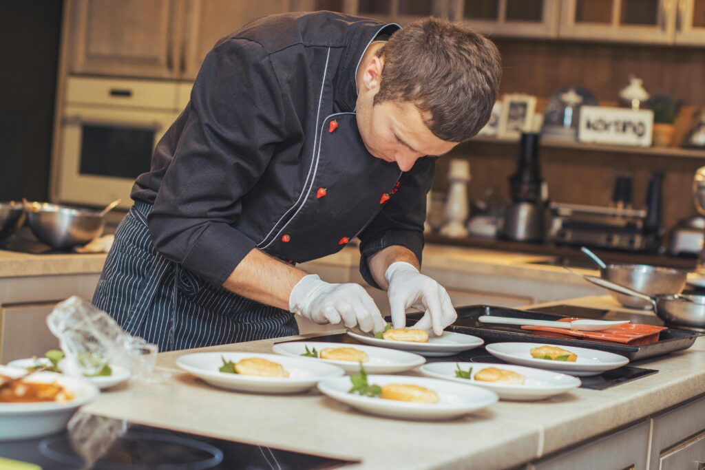 A chef carefully plating food for serving