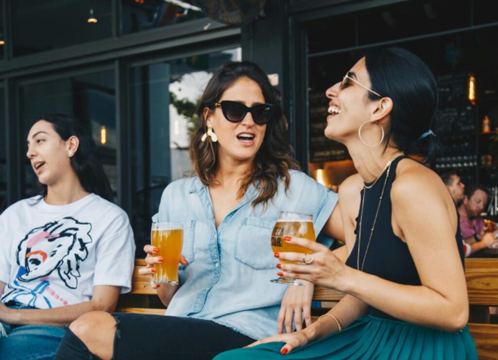 Two friend enjoying a drink and laughing