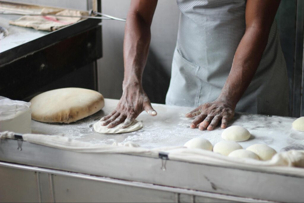 A baker kneading bread dough