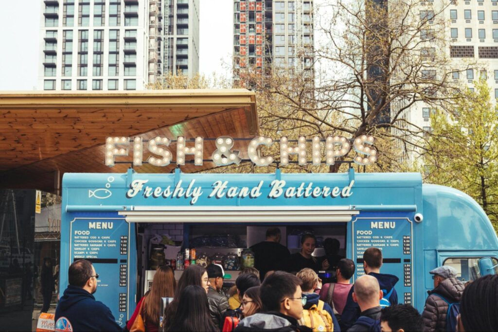 A fish & chip food truck with lots of customers