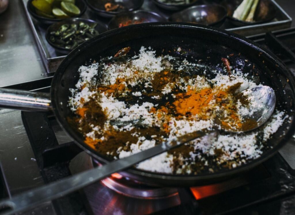 A chef cooking herbs in a pan