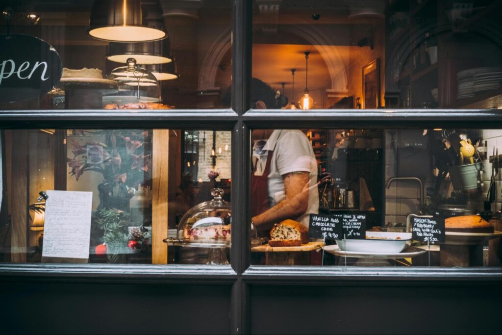 A baker preparing food through the bakery window