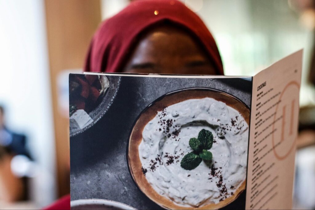 Customer reading menu with large image of food on the back